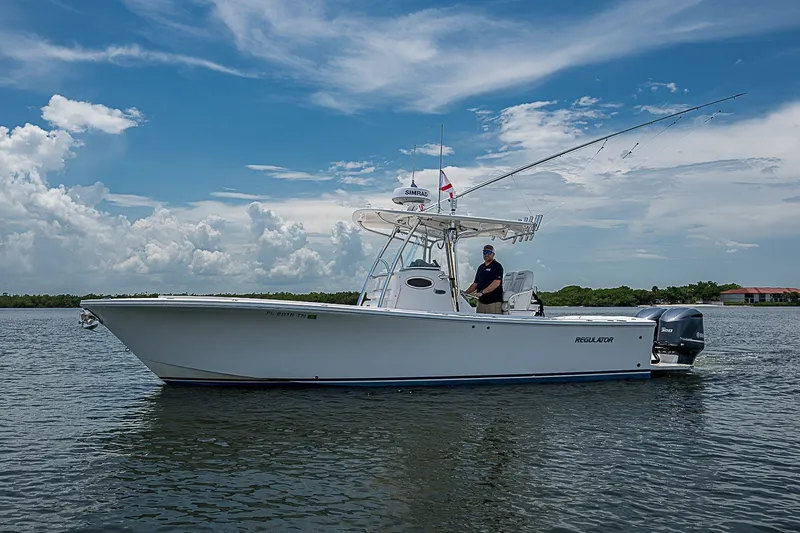 Slide: The Image of 2012 Regulator 28 Forward Seating boat on calm water under a clear sky. - 1