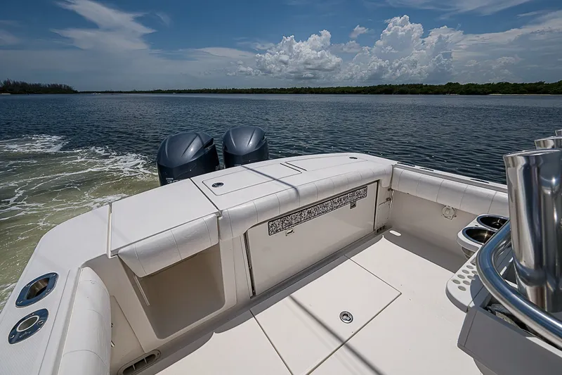 Slide: The Image of 2012 Regulator 28 Forward Seating boat on calm water, featuring dual engines and spacious deck. - 18