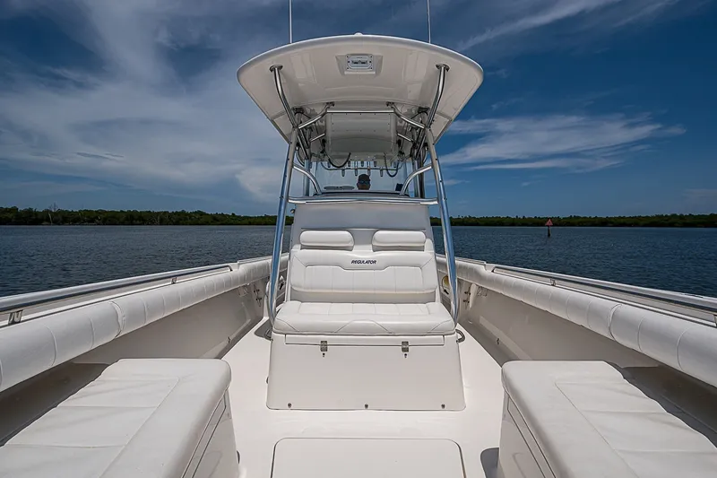 Slide: The Image of 2012 Regulator 28 Forward Seating boat on calm water under blue sky. - 15