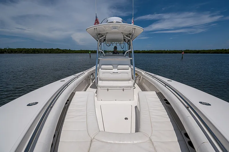 Slide: The Image of 2012 Regulator 28 Forward Seating boat on calm water under blue sky. - 14