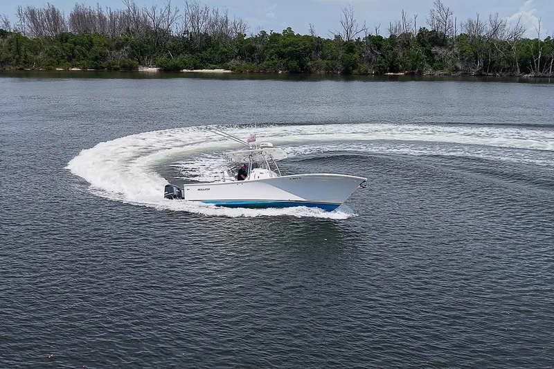 Slide: The Image of 2012 Regulator 28 Forward Seating boat making a sharp turn on a calm lake. - 8
