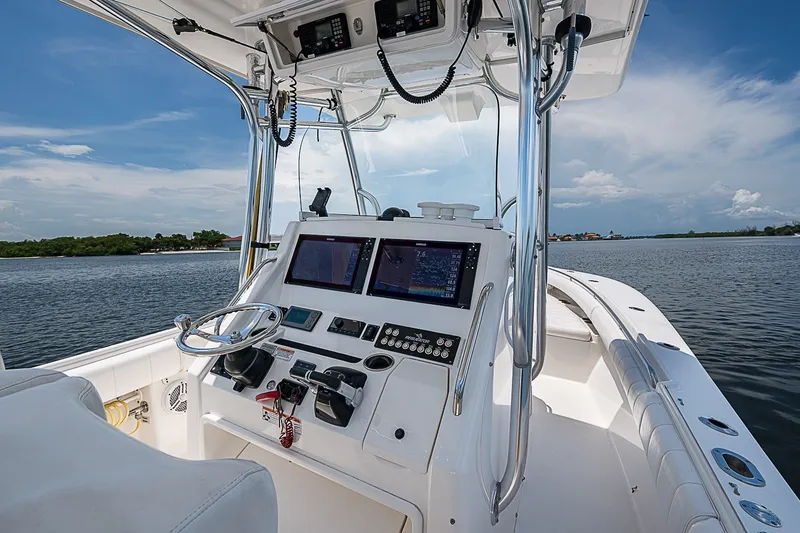 Slide: The Image of 2012 Regulator 28 Forward Seating boat cockpit with navigation screens and steering wheel. - 27