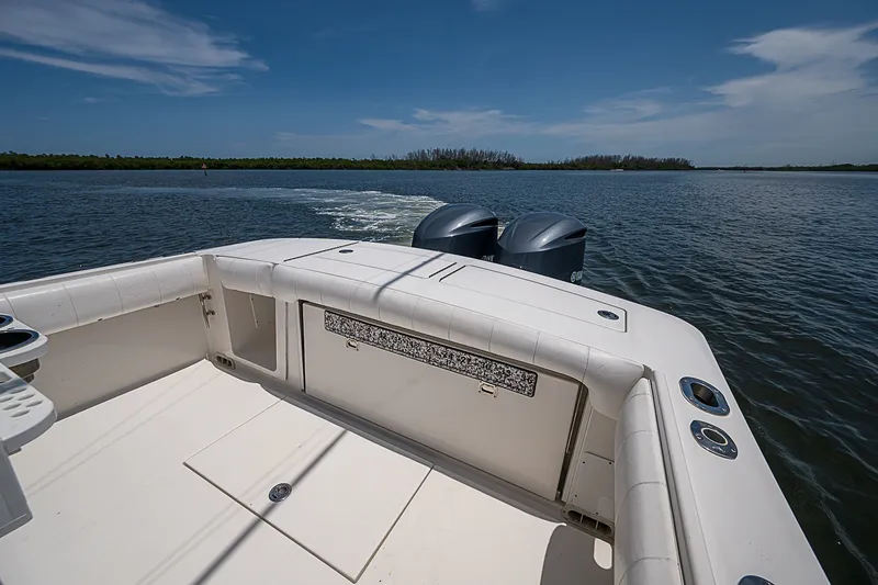 Slide: The Image of 2012 Regulator 28 Forward Seating boat on calm water, featuring dual outboard motors. - 17