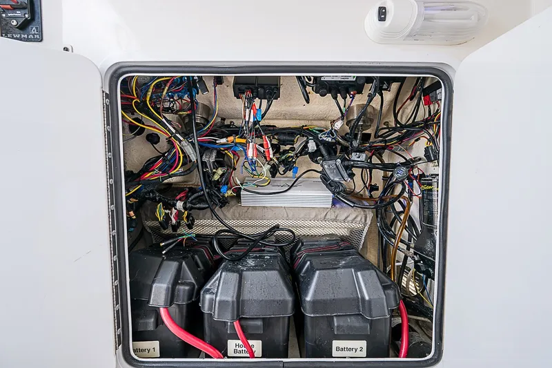 Slide: The Image of Electrical compartment of a 2012 Regulator 28 Forward Seating boat with batteries and wiring. - 25