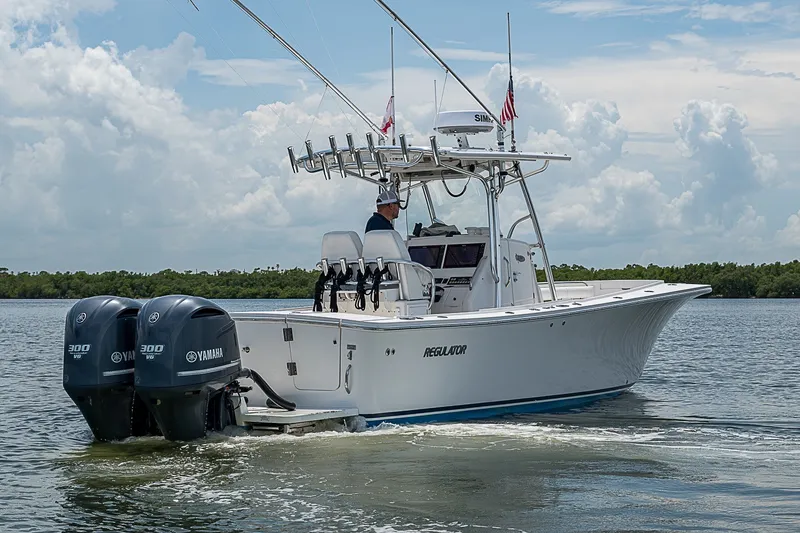 Slide: The Image of 2012 Regulator 28 Forward Seating boat with dual Yamaha engines on water. - 5