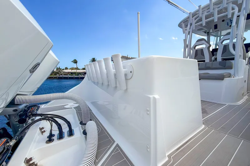Slide: The Image of 2024 Cape Horn 34XS boat deck with seating and rod holders, under a clear blue sky. - 19