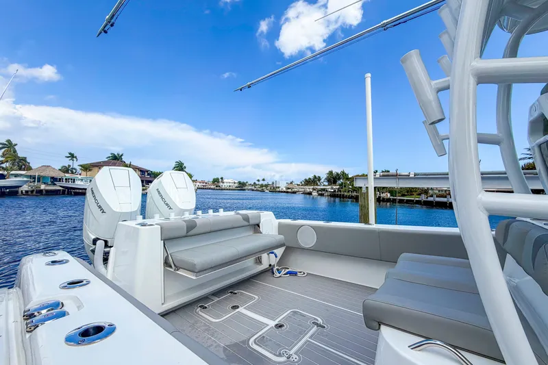 Slide: The Image of 2024 Cape Horn 34XS boat interior with twin Mercury engines, docked by waterfront homes. - 16
