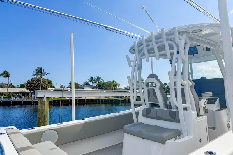 Slide: The Image of 2024 Cape Horn 34XS boat interior with seating and rod holders, docked by a waterfront. - 14