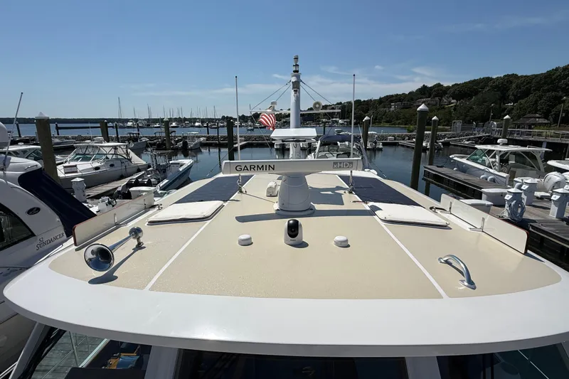 Slide: The Image of 2003 Grand Banks 49 Eastbay HX yacht docked at a marina under clear blue skies. - 22