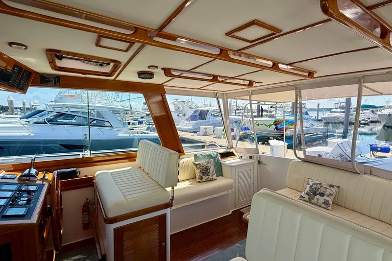 Slide: The Image of Luxurious 2003 Grand Banks 49 Eastbay HX yacht interior with elegant seating and marina view. - 38