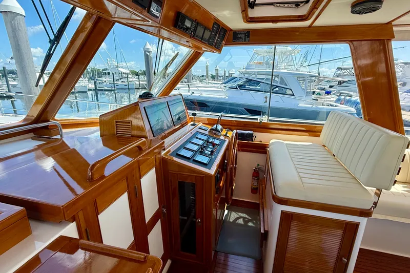 Slide: The Image of Interior view of 2003 Grand Banks 49 Eastbay HX yacht helm with marina background. - 42
