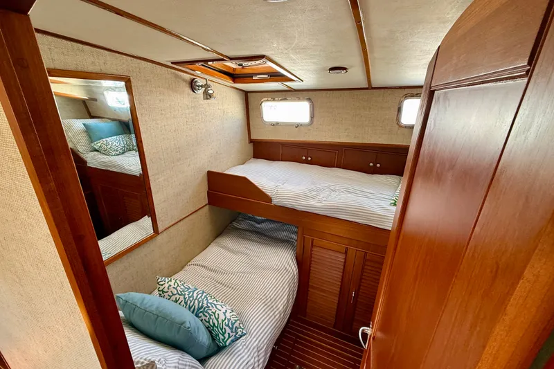 Slide: The Image of Cozy cabin interior of 2003 Grand Banks 49 Eastbay HX with wooden finishes and twin beds. - 58