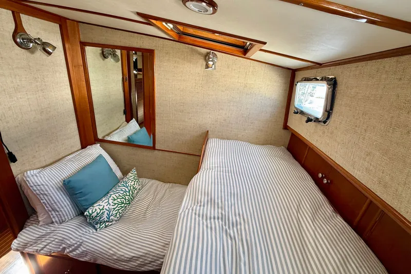 Slide: The Image of Cozy cabin interior of 2003 Grand Banks 49 Eastbay HX with striped bedding and porthole window. - 60