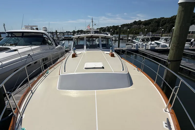Slide: The Image of 2003 Grand Banks 49 Eastbay HX yacht docked at a marina under clear skies. - 17