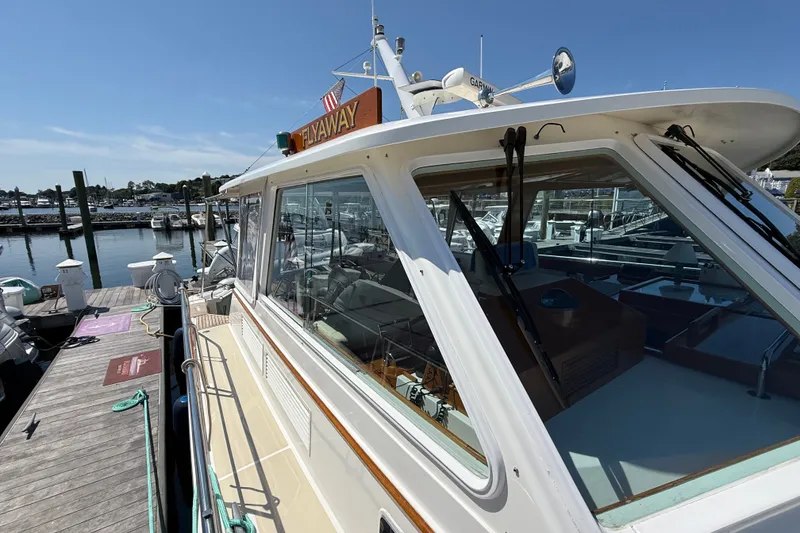 Slide: The Image of 2003 Grand Banks 49 Eastbay HX yacht docked at marina under clear blue sky. - 26