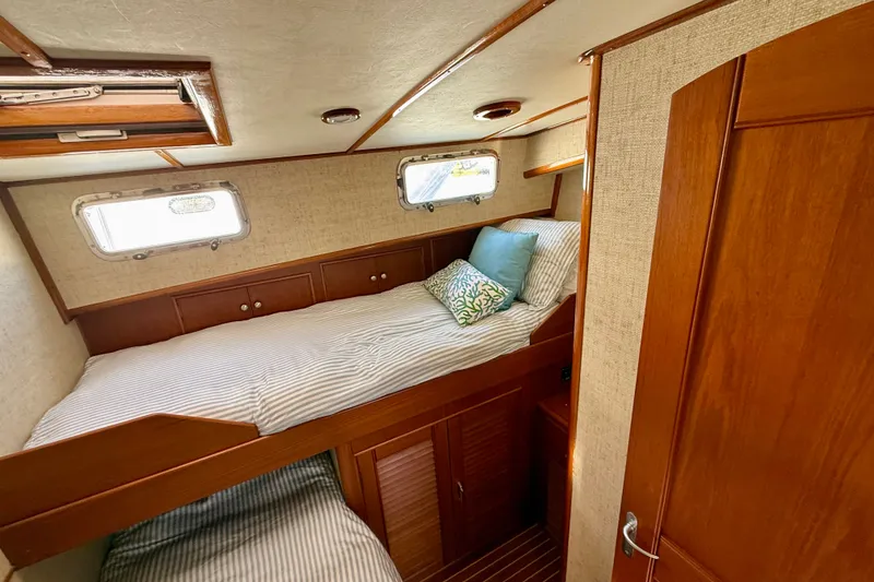 Slide: The Image of Cozy cabin interior of 2003 Grand Banks 49 Eastbay HX with wooden finishes and bedding. - 59