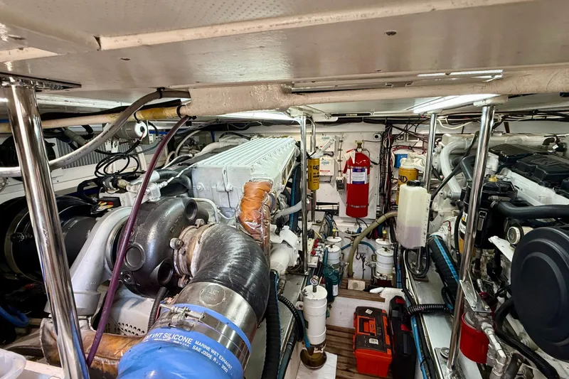 Slide: The Image of Engine room of a 2003 Grand Banks 49 Eastbay HX, featuring mechanical components and fire extinguisher. - 71