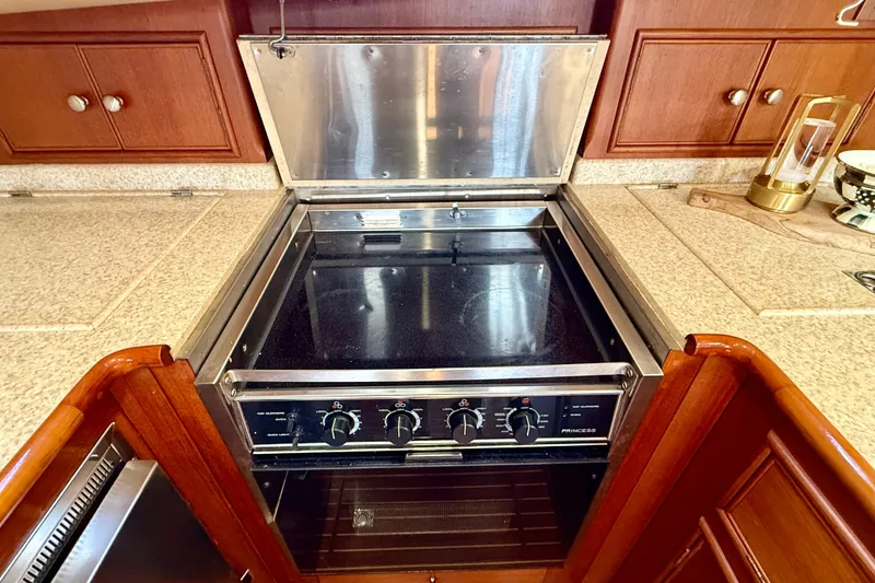 Slide: The Image of Stove in 2003 Grand Banks 49 Eastbay HX yacht kitchen, featuring wooden cabinetry. - 54