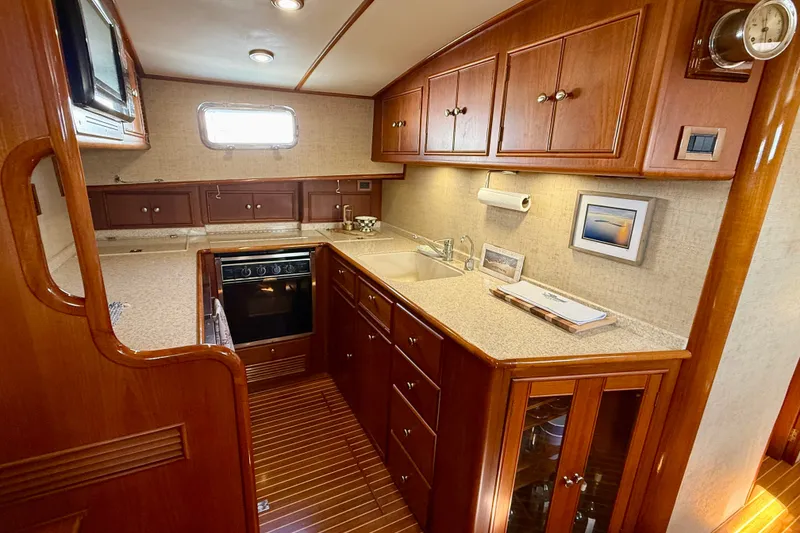 Slide: The Image of Luxurious 2003 Grand Banks 49 Eastbay HX yacht kitchen with wood cabinetry and modern appliances. - 51