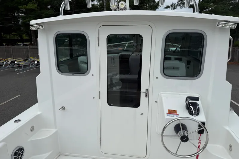 Slide: The Image of 2025 Parker 2520 XLD Sport Cabin boat, rear view of cabin entrance and controls. - 13