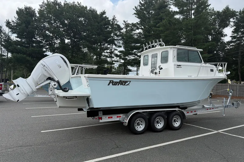 The Image of 2025 Parker 2520 XLD Sport Cabin boat on trailer in parking lot. - 0