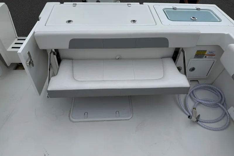 Slide: The Image of 2025 Parker 2520 XLD Sport Cabin boat interior with foldable seat and storage compartments. - 11