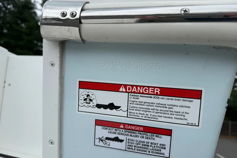 Slide: The Image of 2025 Parker 2520 XLD Sport Cabin warning labels on boat exterior, emphasizing safety precautions. - 12