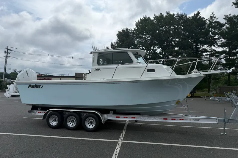 Slide: The Image of 2025 Parker 2520 XLD Sport Cabin boat on trailer in parking lot. - 4