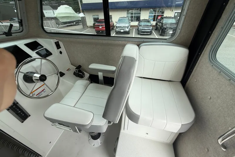 Slide: The Image of Interior of 2025 Parker 2520 XLD Sport Cabin with white seating and steering wheel. - 9