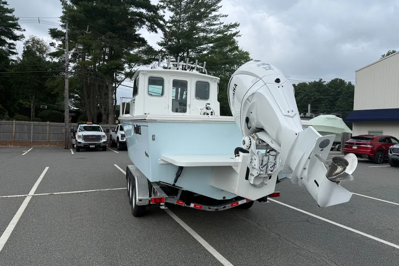 Slide: The Image of 2025 Parker 2520 XLD Sport Cabin boat on trailer in parking lot. - 2