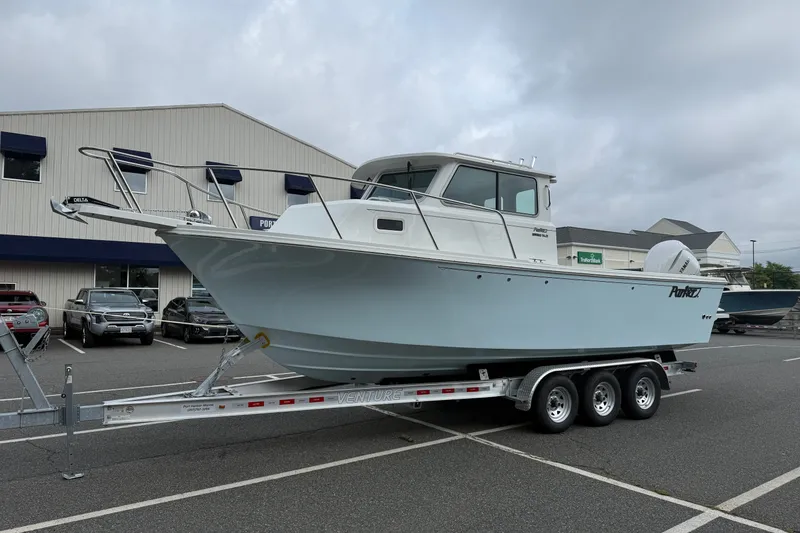 Slide: The Image of 2025 Parker 2520 XLD Sport Cabin boat on trailer in parking lot. - 3