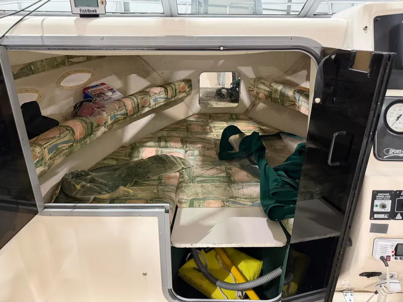 Slide: The Image of The image shows the interior of a 1999 Sport-Craft Sportsman boat with a sleeping area and controls. - 9