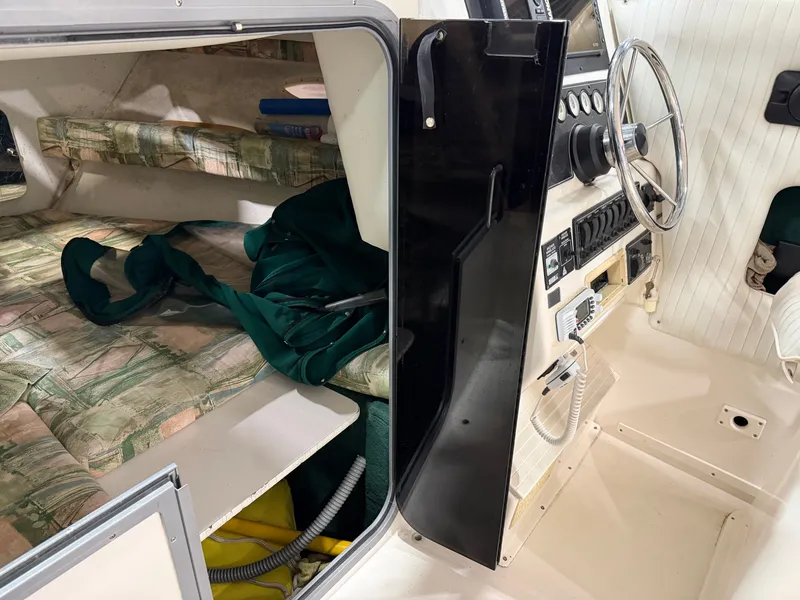 Slide: The Image of Interior of a 1999 Sport-Craft Sportsman with helm and sleeping area. - 10