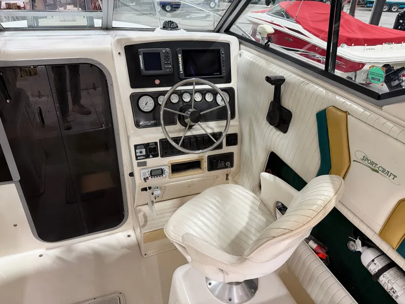 Slide: The Image of The cockpit of a 1999 Sport-Craft Sportsman with steering wheel, instruments, and a white seat. - 7