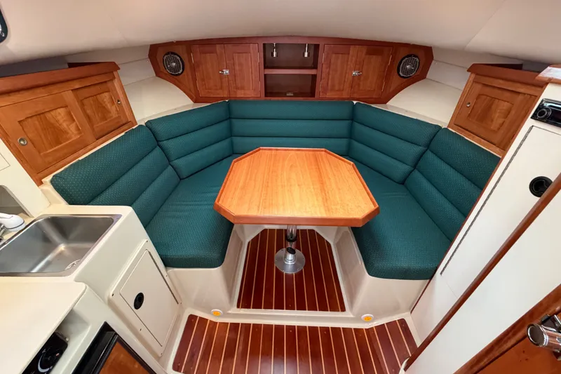 Slide: The Image of Interior of 2006 Albin 28 Gatsby Edition with green seating and wooden table. - 31