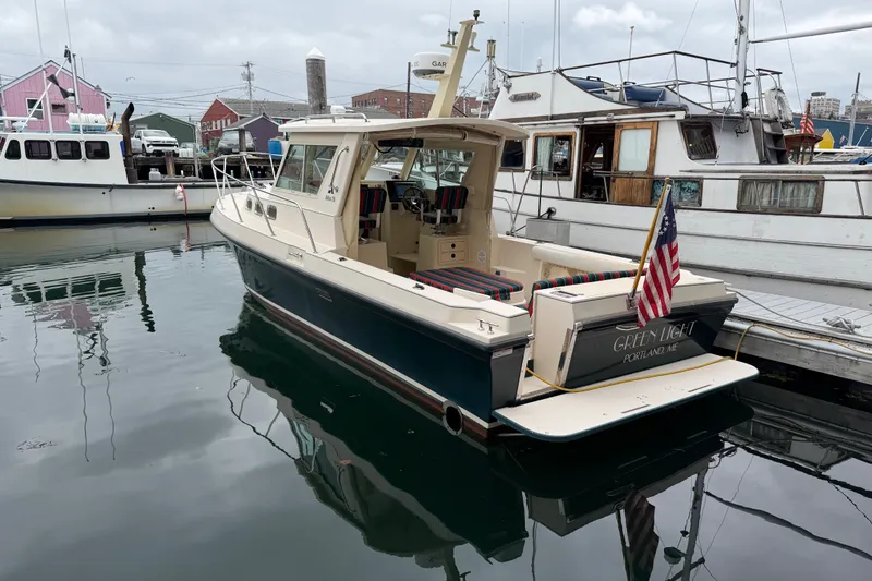 Slide: The Image of 2006 Albin 28 Gatsby Edition boat docked in a marina, displaying an American flag. - 17