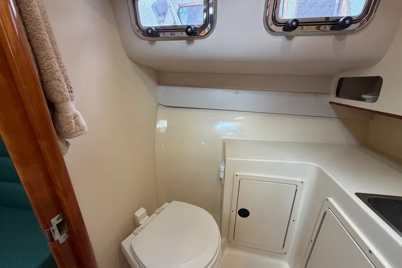 Slide: The Image of 2006 Albin 28 Gatsby Edition boat bathroom with toilet and porthole windows. - 38