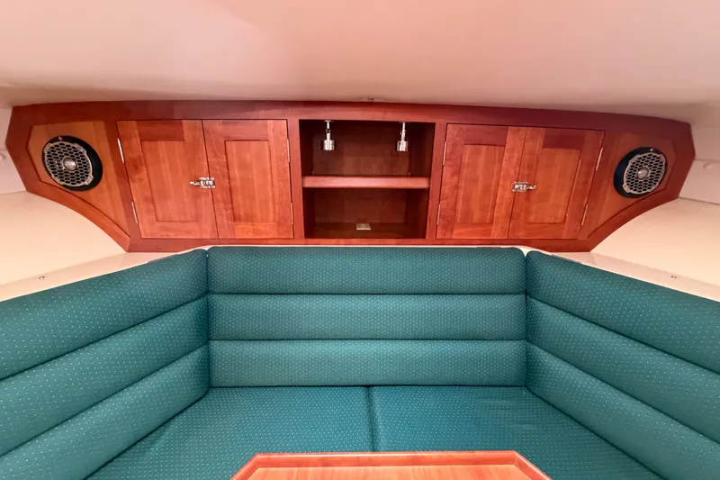 Slide: The Image of Interior of 2006 Albin 28 Gatsby Edition with wood cabinets and green seating. - 34
