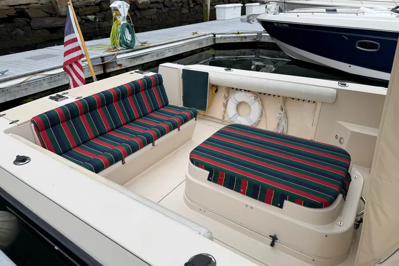 Slide: The Image of 2006 Albin 28 Gatsby Edition boat with striped seating, docked near other vessels. - 19