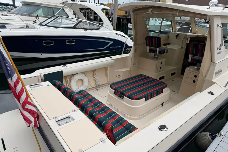 Slide: The Image of 2006 Albin 28 Gatsby Edition boat with striped seating, docked alongside other vessels. - 18