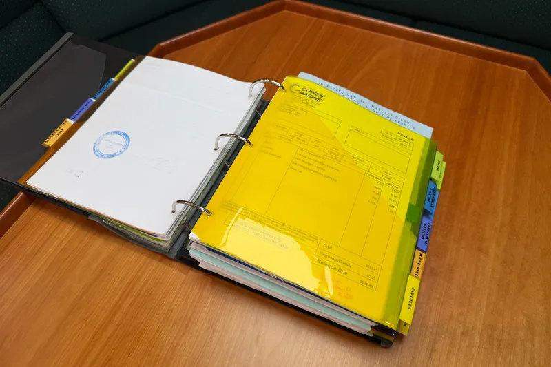 Slide: The Image of Open binder with documents and invoices on a wooden table, related to Albin 28 Gatsby Edition 2006. - 46