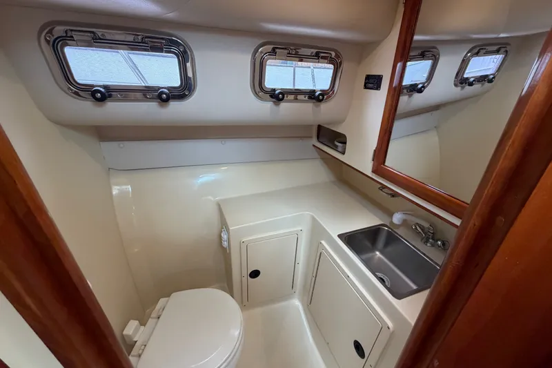Slide: The Image of 2006 Albin 28 Gatsby Edition boat bathroom with sink, toilet, and porthole windows. - 36