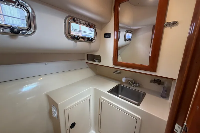 Slide: The Image of Interior of 2006 Albin 28 Gatsby Edition boat, featuring a compact bathroom with sink and mirror. - 37