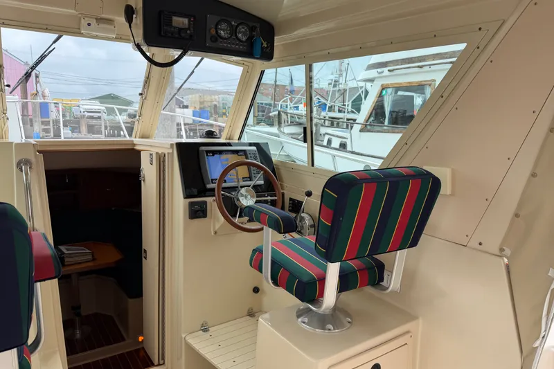 Slide: The Image of 2006 Albin 28 Gatsby Edition boat interior with striped captain's chair and navigation equipment. - 23