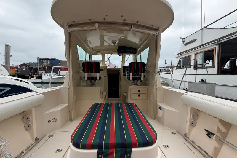 Slide: The Image of 2006 Albin 28 Gatsby Edition boat interior with striped seating, docked at a marina. - 21