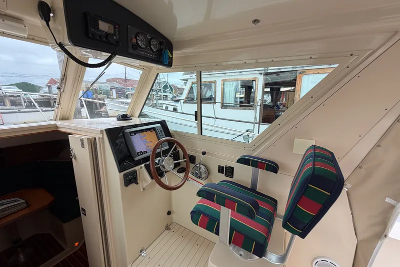 Slide: The Image of Interior of 2006 Albin 28 Gatsby Edition boat with striped seating and navigation controls. - 25