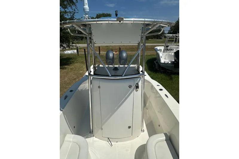 Slide: The Image of 2012 Sundance NX25 boat with T-top and center console, parked on grass. - 34