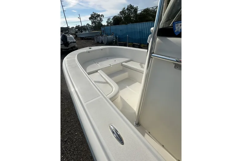 Slide: The Image of 2012 Sundance NX25 boat deck with seating, parked outdoors on gravel. - 13