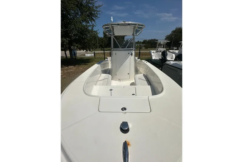 Slide: The Image of 2012 Sundance NX25 boat with center console, parked outdoors under a clear sky. - 14