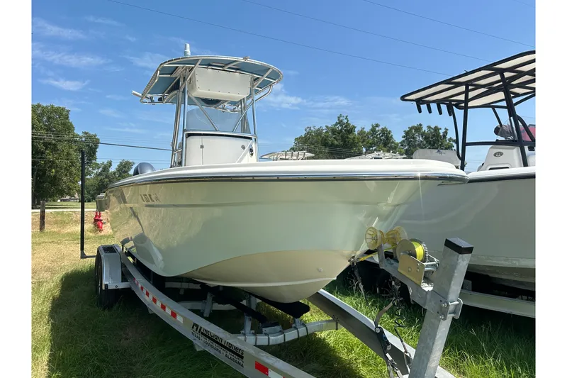 Slide: The Image of 2012 Sundance NX25 boat on trailer, parked outdoors under clear blue sky. - 42